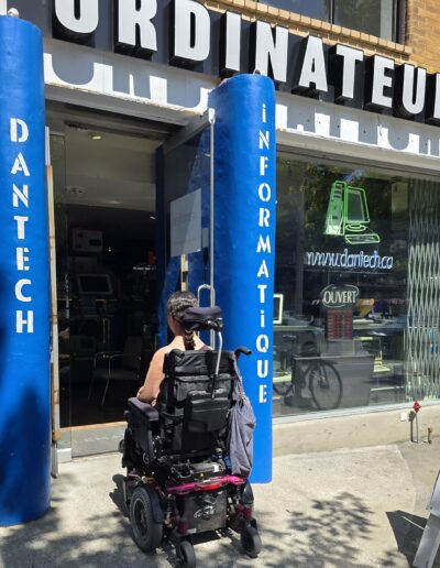 Personne en fauteuil roulant entrant dans un commerce ordinateur du Plateau-Mont-Royal pour documenter l’accessibilité des commerces.